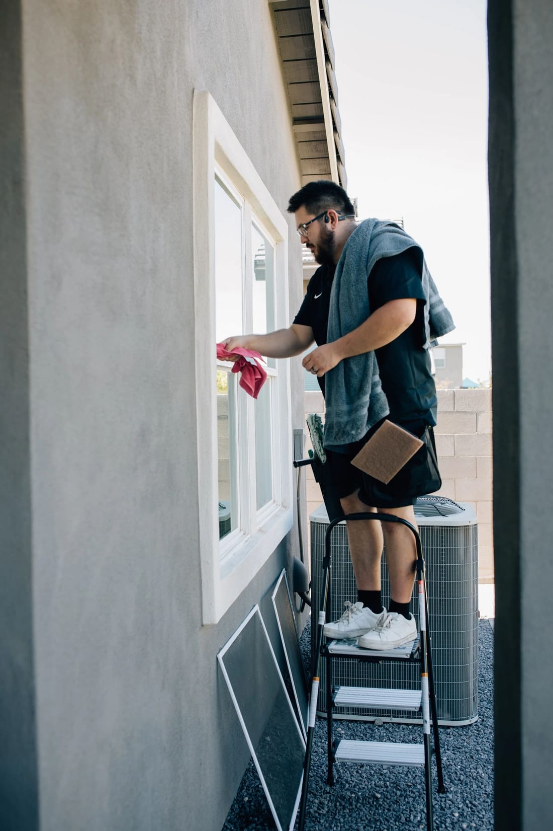 Logan cleaning a home's window in the East Valley